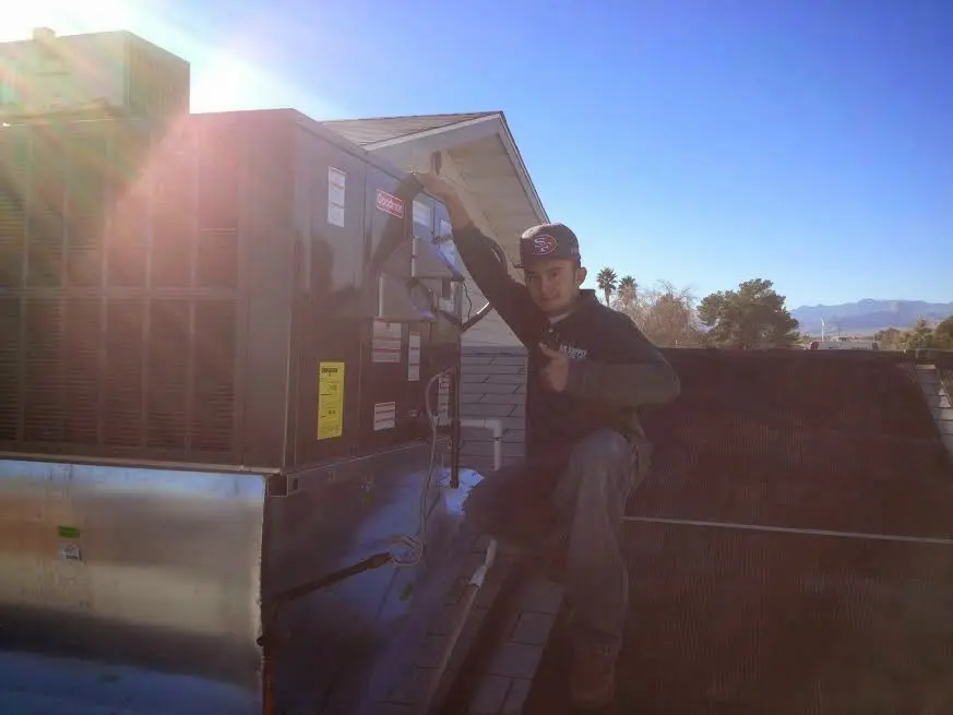 HVAC technician performing AC Tune-Up on a rooftop unit in Weston